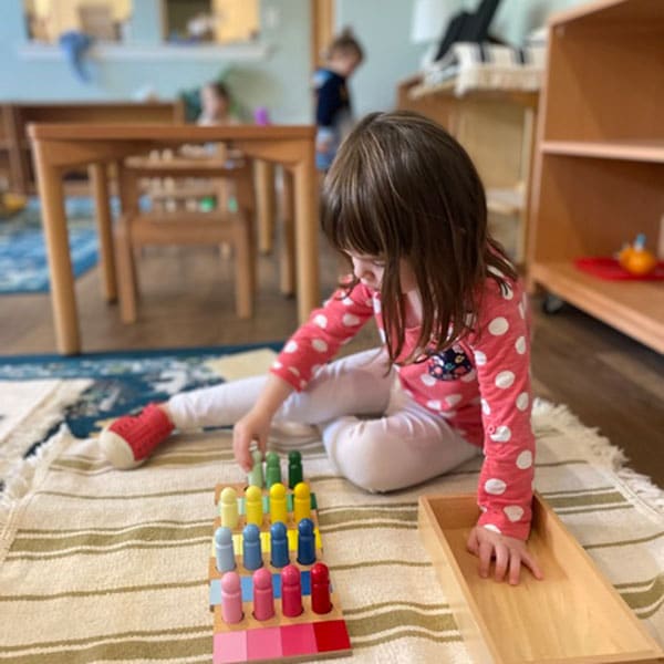 Girl playing with toy in a classroom